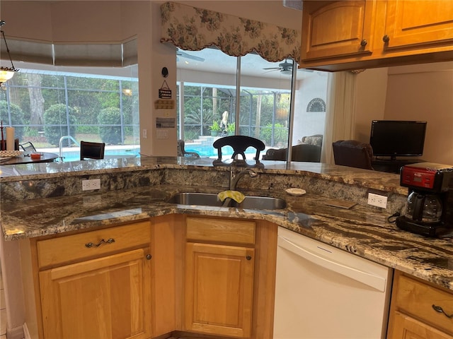 kitchen with a sunroom, a sink, stone counters, dishwasher, and a ceiling fan