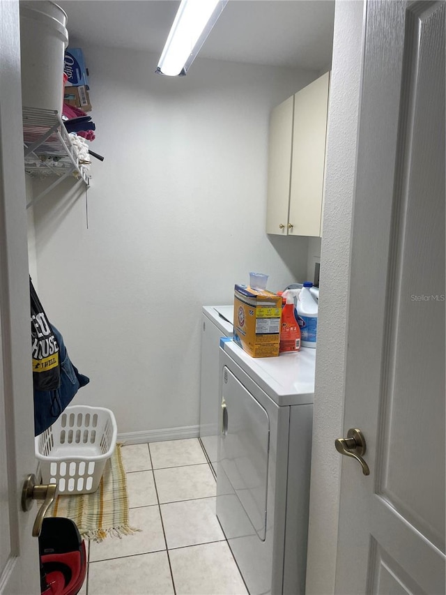 laundry room with light tile patterned floors, cabinet space, baseboards, and separate washer and dryer