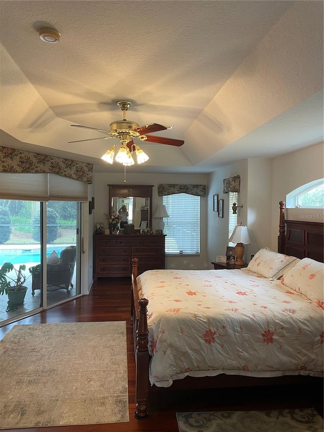 bedroom featuring multiple windows, access to outside, and a textured ceiling