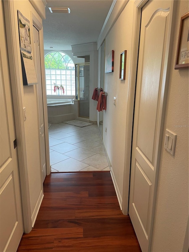 hallway featuring baseboards and tile patterned flooring