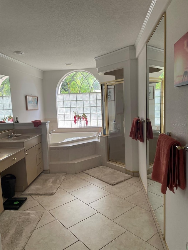 bathroom featuring tile patterned floors, crown molding, vanity, a textured ceiling, and a bath