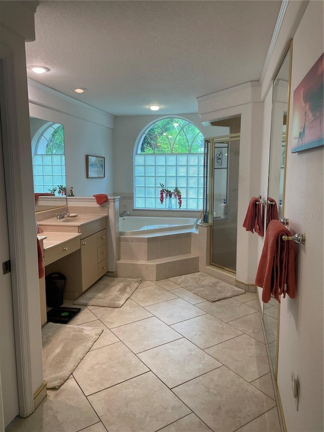 full bath featuring vanity, a garden tub, a shower stall, a textured ceiling, and ornamental molding