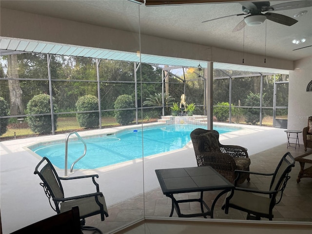 outdoor pool featuring a patio, a ceiling fan, and a lanai