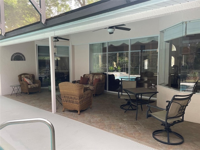 view of patio / terrace featuring glass enclosure, an outdoor living space, and a ceiling fan