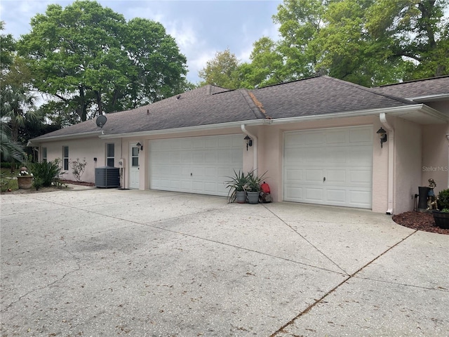 view of front of home featuring stucco siding, driveway, a garage, and roof with shingles