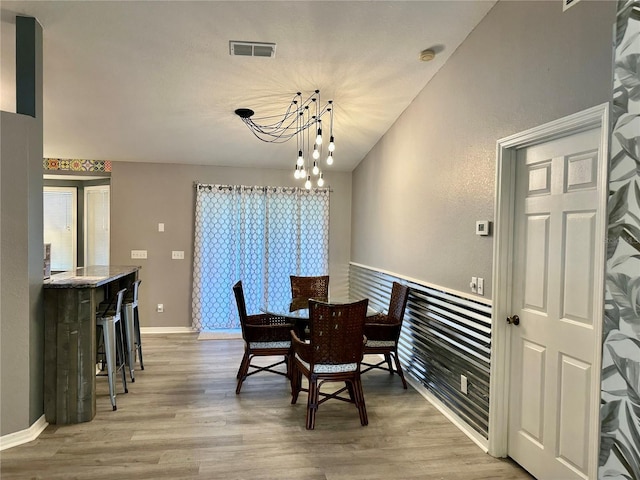 6082 SW 104th St, Ocala, FL 34476 - dining area with light wood-type flooring, a chandelier, and baseboards