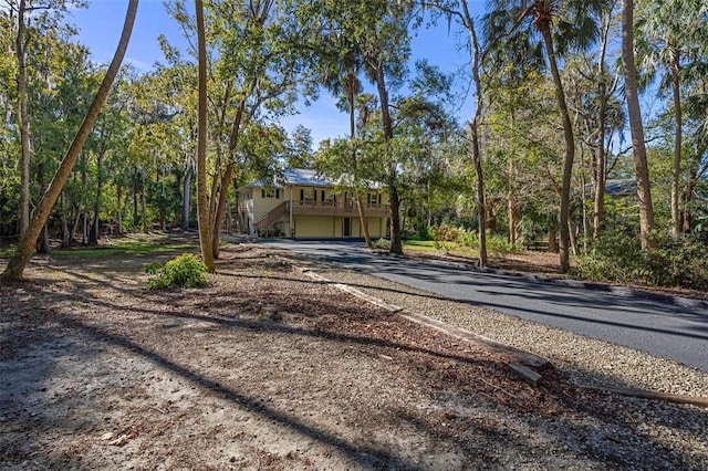 view of front facade with a garage, stairway, and aphalt driveway