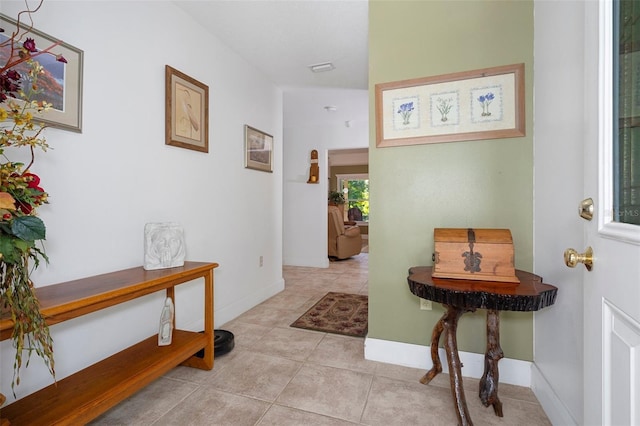 corridor with light tile patterned flooring and baseboards