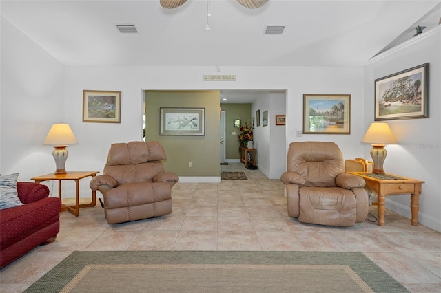 living room with baseboards, visible vents, vaulted ceiling, and light tile patterned floors