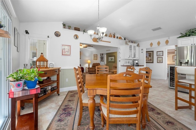 dining area featuring vaulted ceiling, a chandelier, a wainscoted wall, beverage cooler, and visible vents