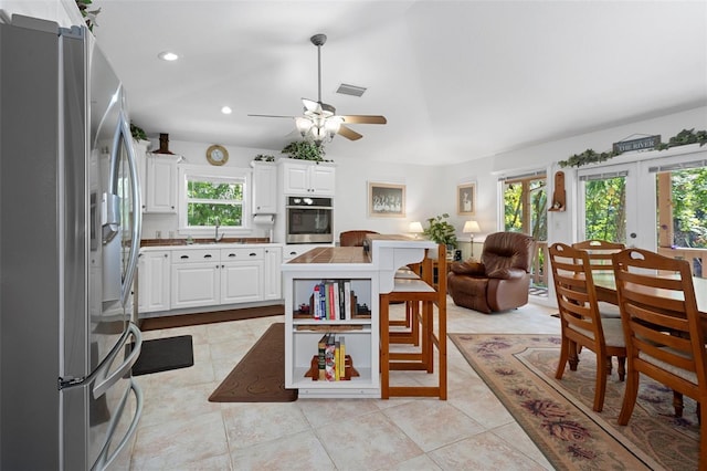 kitchen with white cabinets, visible vents, a ceiling fan, appliances with stainless steel finishes, and a sink