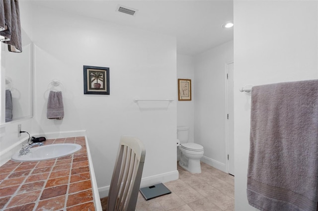 bathroom with visible vents, baseboards, toilet, tile patterned floors, and vanity