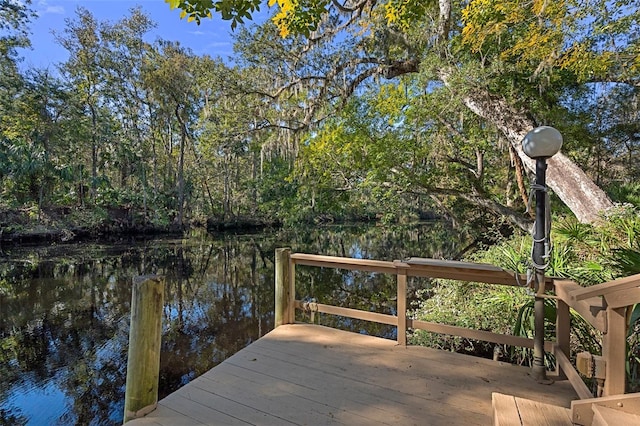 dock area with a water view and a forest view