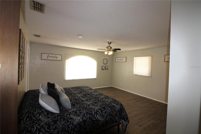 bedroom featuring dark wood-style flooring, baseboards, multiple windows, and visible vents
