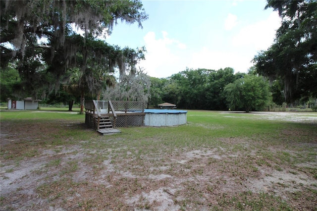 view of yard featuring an outdoor pool and a deck