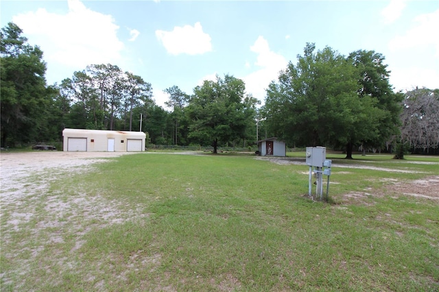 view of yard with a storage unit, an outbuilding, and a garage