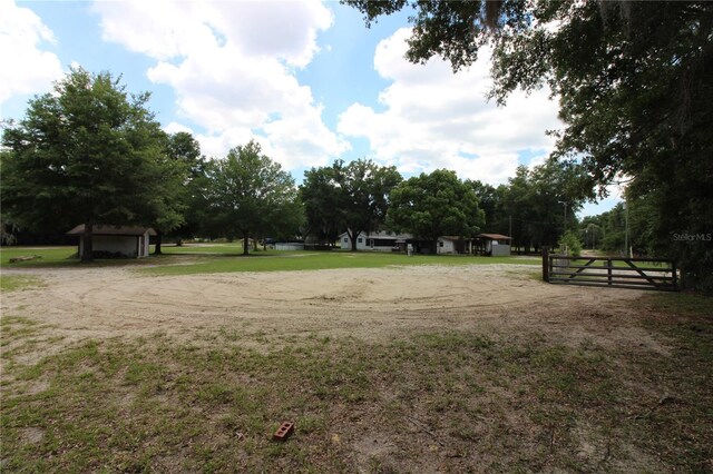 surrounding community with driveway, a detached garage, and fence