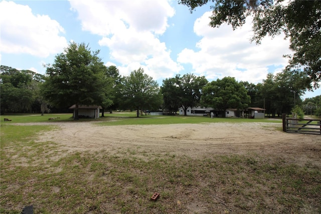 view of property's community with driveway, fence, and a lawn