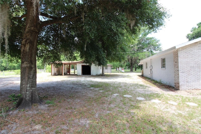 view of yard with an outdoor structure, a pole building, and a garage