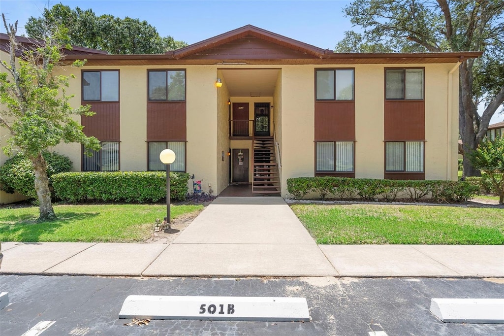 501 Fairways Ln Unit A, Ocala, FL 34472 - view of front of house featuring stairs, a front yard, and stucco siding