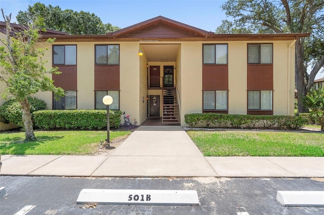 501 Fairways Ln Unit A, Ocala, FL 34472 - view of front of house featuring stairs, a front yard, and stucco siding