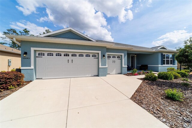 10445 SW 90th Street Rd, Ocala, FL 34481 - view of front of house featuring stucco siding, driveway, and an attached garage