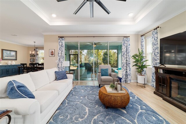 10445 SW 90th Street Rd, Ocala, FL 34481 - living area featuring ceiling fan, a raised ceiling, wood finished floors, crown molding, and a chandelier