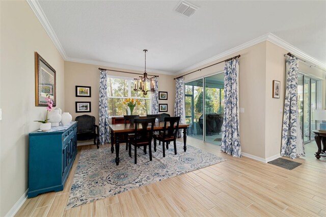 10445 SW 90th Street Rd, Ocala, FL 34481 - dining space with a chandelier, light wood-style flooring, healthy amount of natural light, baseboards, and ornamental molding