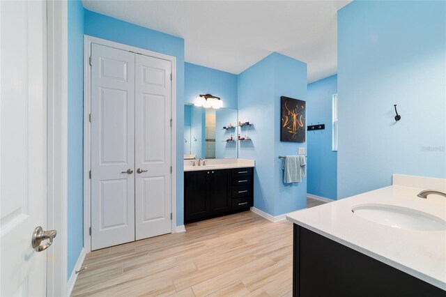 10445 SW 90th Street Rd, Ocala, FL 34481 - bathroom with two vanities, wood finished floors, baseboards, and a closet