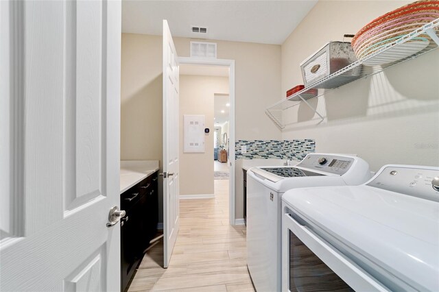 10445 SW 90th Street Rd, Ocala, FL 34481 - laundry area featuring washing machine and clothes dryer, baseboards, and light wood-style flooring