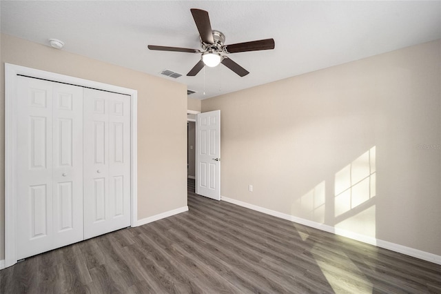 unfurnished bedroom with baseboards, ceiling fan, visible vents, a closet, and wood finished floors