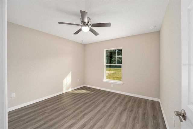 empty room featuring baseboards, wood finished floors, and ceiling fan