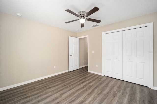 unfurnished bedroom with baseboards, visible vents, a ceiling fan, a closet, and wood finished floors