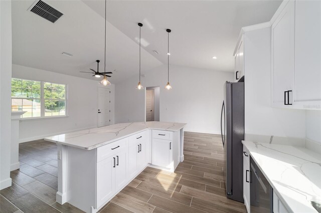 kitchen featuring appliances with stainless steel finishes, vaulted ceiling, a kitchen island, wood tiled floors, and white cabinetry