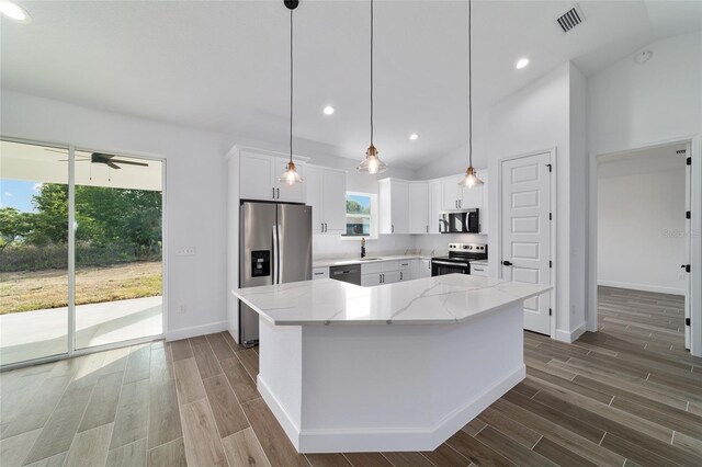 kitchen featuring appliances with stainless steel finishes, dark wood-style floors, light stone counters, baseboards, and recessed lighting