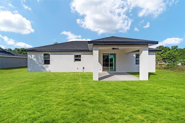 back of property featuring a ceiling fan, a patio, a lawn, and stucco siding