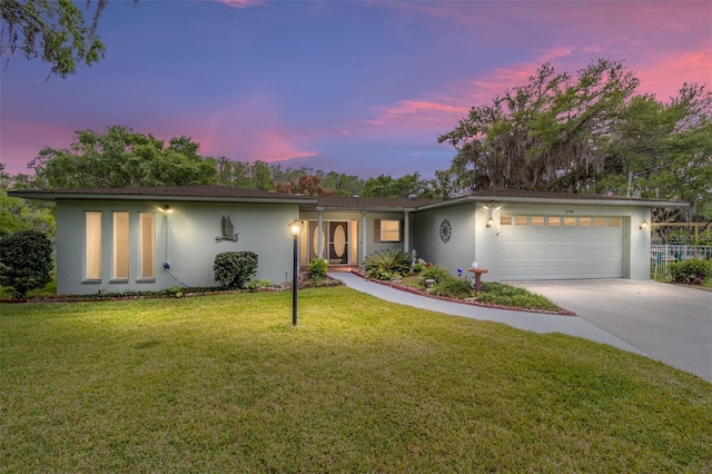 12180 Maple St, Dunnellon, FL 34432 - view of front of home featuring an attached garage, stucco siding, concrete driveway, and a front lawn