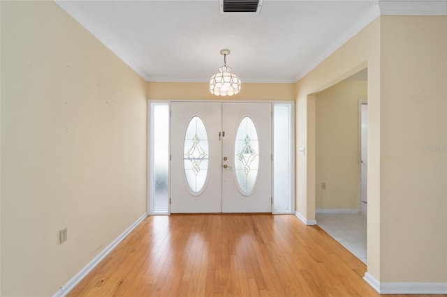 12180 Maple St, Dunnellon, FL 34432 - entryway featuring light wood-style floors, baseboards, a chandelier, and ornamental molding