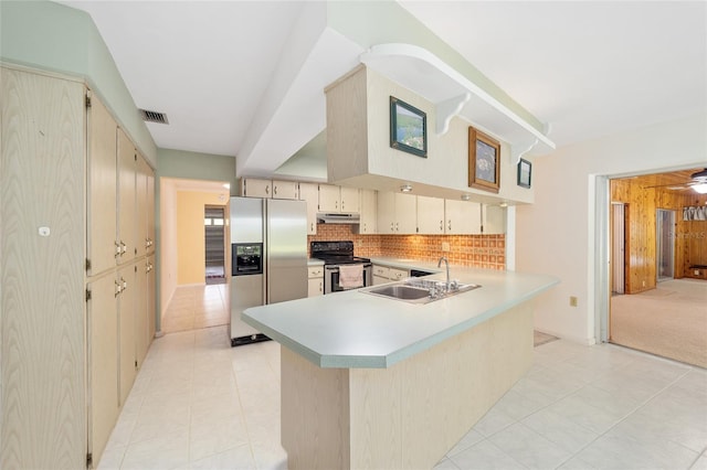 12180 Maple St, Dunnellon, FL 34432 - kitchen with appliances with stainless steel finishes, a sink, cream cabinetry, under cabinet range hood, and light tile patterned flooring