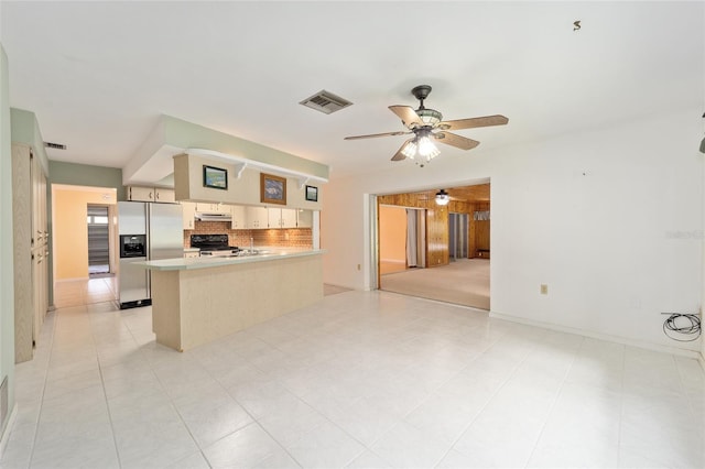 12180 Maple St, Dunnellon, FL 34432 - kitchen featuring stainless steel fridge, stove, backsplash, ceiling fan, and a peninsula