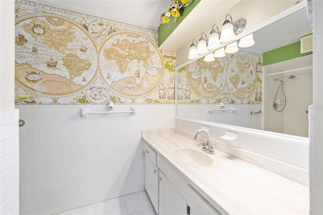 12180 Maple St, Dunnellon, FL 34432 - bathroom with vanity, a shower, wainscoting, tile walls, and tile patterned floors