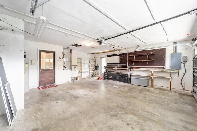 12180 Maple St, Dunnellon, FL 34432 - garage with electric panel, a workshop area, a garage door opener, and water heater