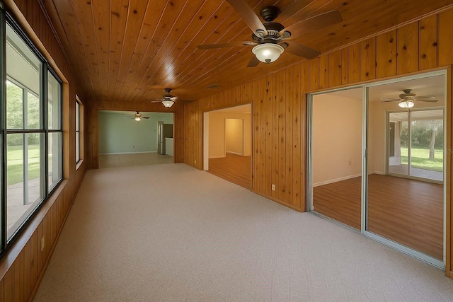 12180 Maple St, Dunnellon, FL 34432 - spare room featuring ceiling fan, wood ceiling, wooden walls, light carpet, and baseboards
