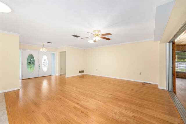 12180 Maple St, Dunnellon, FL 34432 - unfurnished living room with ceiling fan, light wood finished floors, plenty of natural light, crown molding, and a chandelier