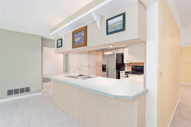 12180 Maple St, Dunnellon, FL 34432 - kitchen with stainless steel fridge, black range with electric cooktop, light countertops, and decorative backsplash