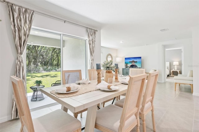 dining space with baseboards, visible vents, and light tile patterned floors