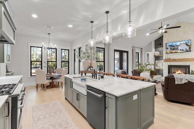 5024 N Tumblewood Dr, Crystal River, FL 34428 - kitchen featuring gray cabinets, range hood, a sink, a stone fireplace, and stainless steel appliances