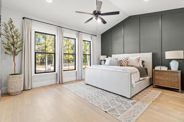 5024 N Tumblewood Dr, Crystal River, FL 34428 - bedroom with a decorative wall, vaulted ceiling, light wood-style flooring, and ceiling fan