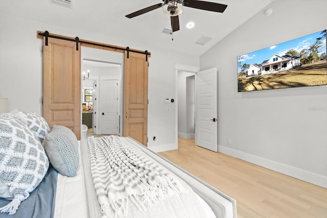 5024 N Tumblewood Dr, Crystal River, FL 34428 - bedroom featuring visible vents, baseboards, wood finished floors, a barn door, and vaulted ceiling