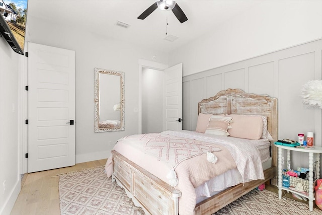 5024 N Tumblewood Dr, Crystal River, FL 34428 - bedroom with light wood finished floors, visible vents, ceiling fan, and a decorative wall